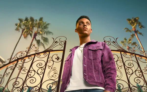 Bel-Air 4K Ultra HD PC desktop wallpaper — young man in a purple jacket stands before ornate wrought-iron gates and tall palm trees beneath a warm golden sky.