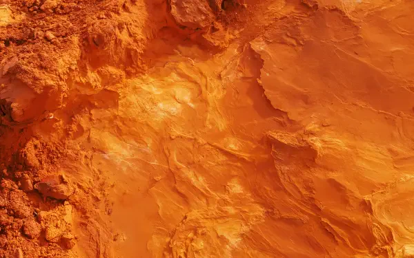 2K Quad HD PC desktop wallpaper showing ocre sandstone rock texture with rich orange-red striations and a rugged, layered surface.
