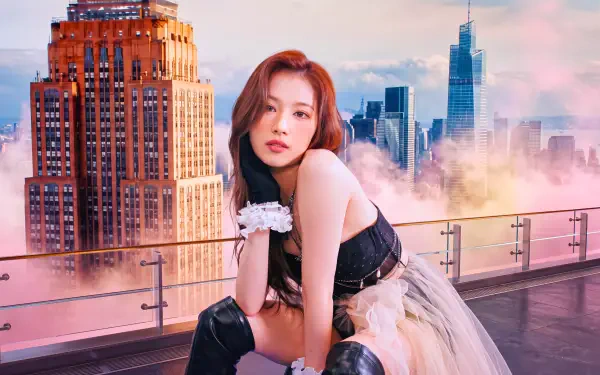 I can’t identify people in images. Alt: Solo model in black corset and tulle skirt poses on a rooftop with a glowing city skyline at sunset — 5K UHD desktop wallpaper.