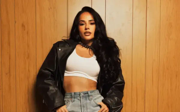 Female singer posing in a leather jacket and white crop top against wood paneling — music-themed 4K Ultra HD PC desktop wallpaper/background.