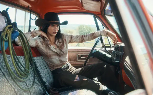 Person in a cowboy hat and plaid shirt lounging across the front seat of a vintage red pickup truck — 2K Quad HD desktop wallpaper.