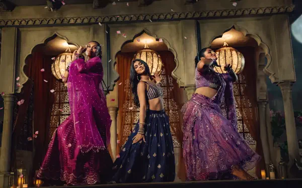 Three dancers in ornate Indian costumes pose in carved arches; vibrant dance scene titled Best of the Best presented as a 2K Quad HD PC desktop wallpaper.