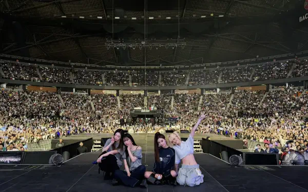 Four performers pose on a stadium stage at the SYNK Complexity concert, a packed crowd and sea of lights behind them — 4K Ultra HD PC desktop wallpaper and background.