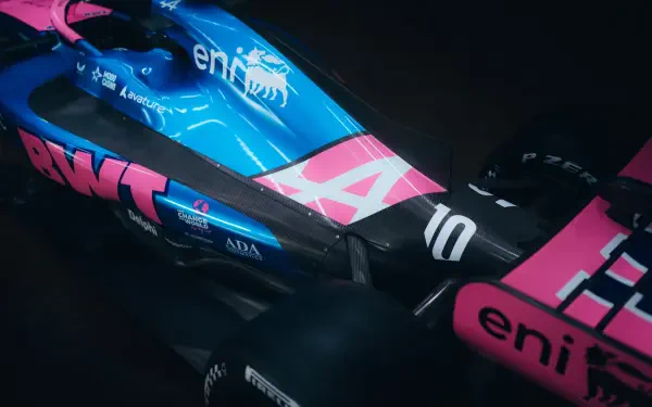 Alpine A526 F1 race car in blue and pink livery, featured in an 8K Ultra HD desktop wallpaper background.