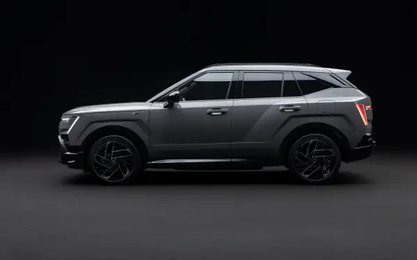 Gray Hyundai Tucson SUV in side profile against a dark studio backdrop, featured in an 8K Ultra HD PC desktop wallpaper.