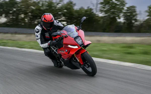 BMW Motorrad F 450 RR motorcycle racer leaning into a turn on a track, featured in an 8K Ultra HD PC desktop wallpaper background.