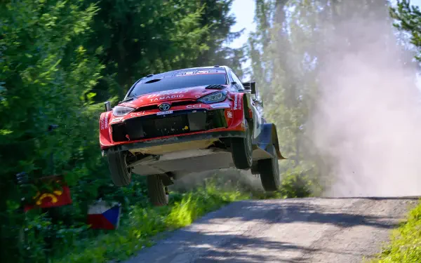 Toyota Gazoo Racing GR Yaris Rally1 rally car airborne on a forest road during WRC action, 4K Ultra HD desktop wallpaper.
