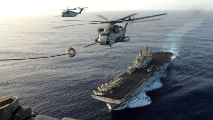 Military Sikorsky CH-53 Sea Stallion helicopters hover over a naval aircraft carrier at sea, captured in an HD PC desktop wallpaper background.