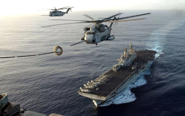 Military Sikorsky CH-53 Sea Stallion helicopters hover over a naval aircraft carrier at sea, captured in an HD PC desktop wallpaper background.
