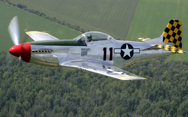 A striking HD wallpaper featuring a military aircraft soaring above lush green landscapes, showcasing its polished design and vibrant checkerboard tail.