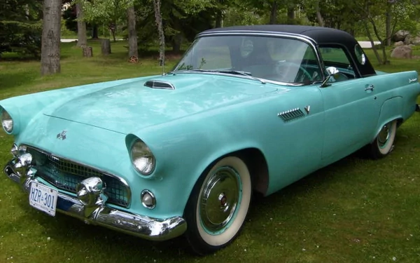 Turquoise 1950s Ford Thunderbird convertible with whitewall tires and chrome trim parked on grass, HD PC desktop wallpaper/background.