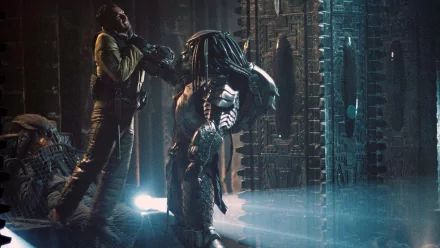 A dramatic HD wallpaper from AVP: Alien vs. Predator, featuring the Celtic Predator confronting a human amid an ancient, atmospheric setting.