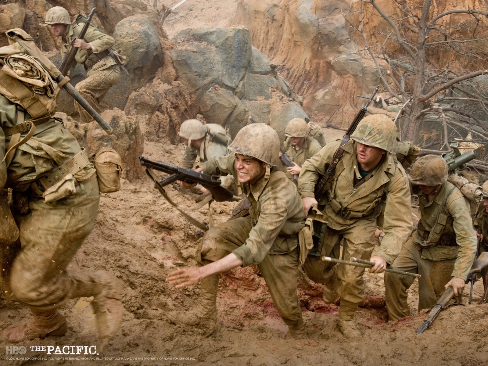 HD PC desktop wallpaper from TV show The Pacific (2010): WWII US Marines in helmets and packs scrambling up a muddy, rocky beach amid smoke and chaos.