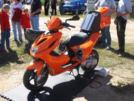 HD desktop wallpaper featuring an orange scooter parked outdoors on a sunny day.