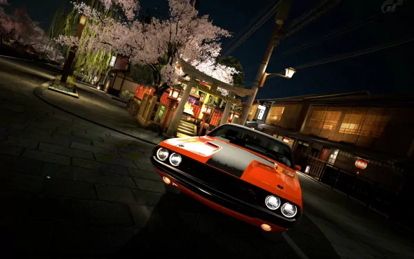 HD PC desktop wallpaper featuring a classic orange muscle car parked on a nighttime street with illuminated buildings and blooming cherry blossom trees.
