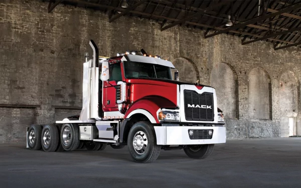 HD PC desktop wallpaper featuring a red Mack Trucks vehicle parked inside an industrial-style building with brick walls and arched windows.