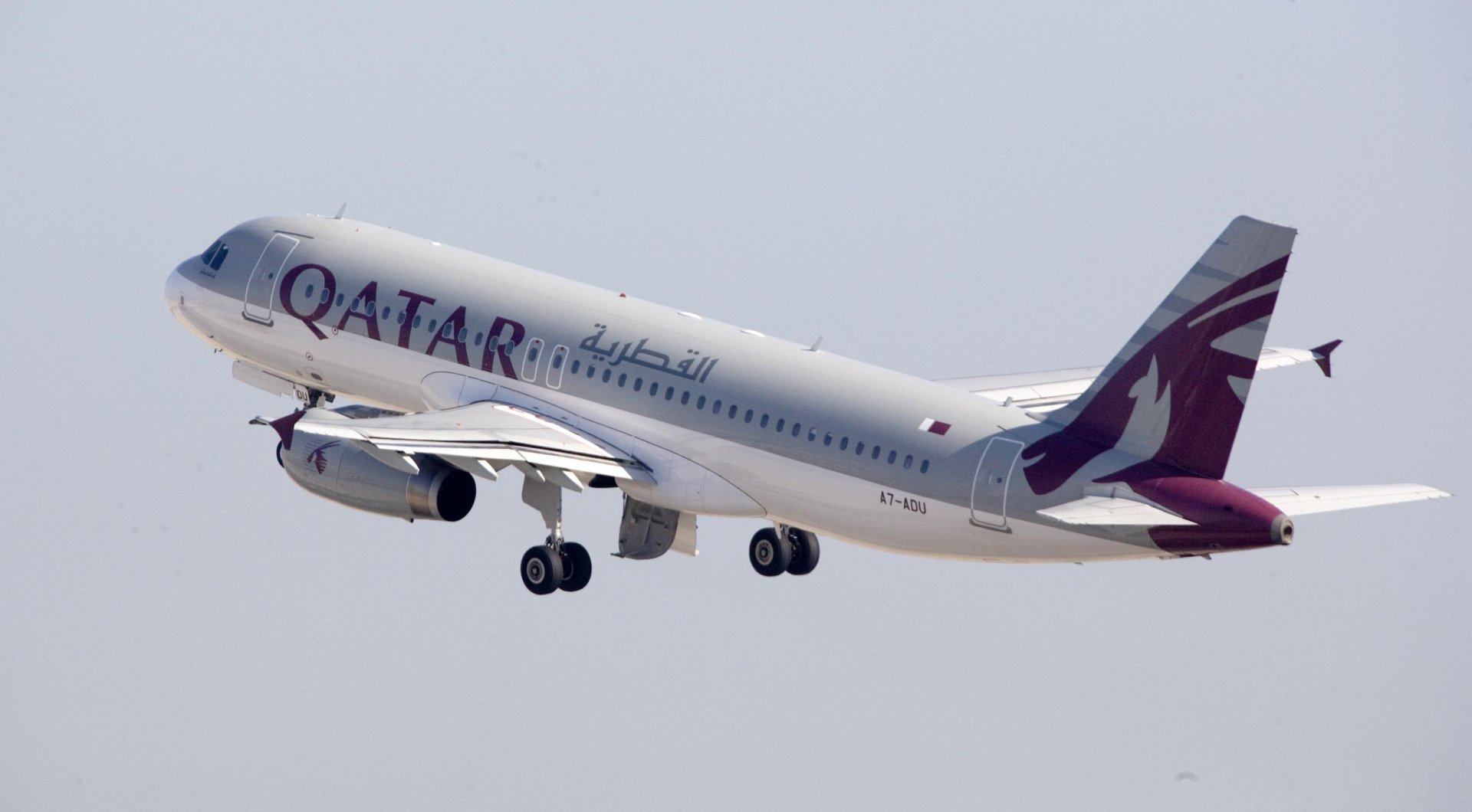 Qatar Airways jet aircraft (vehicle) climbing into a pale sky — 2K Quad HD PC desktop wallpaper/background.