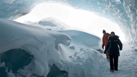 HD PC desktop wallpaper of two figures walking inside an icy cave, inspired by the movie The Thing (2011).