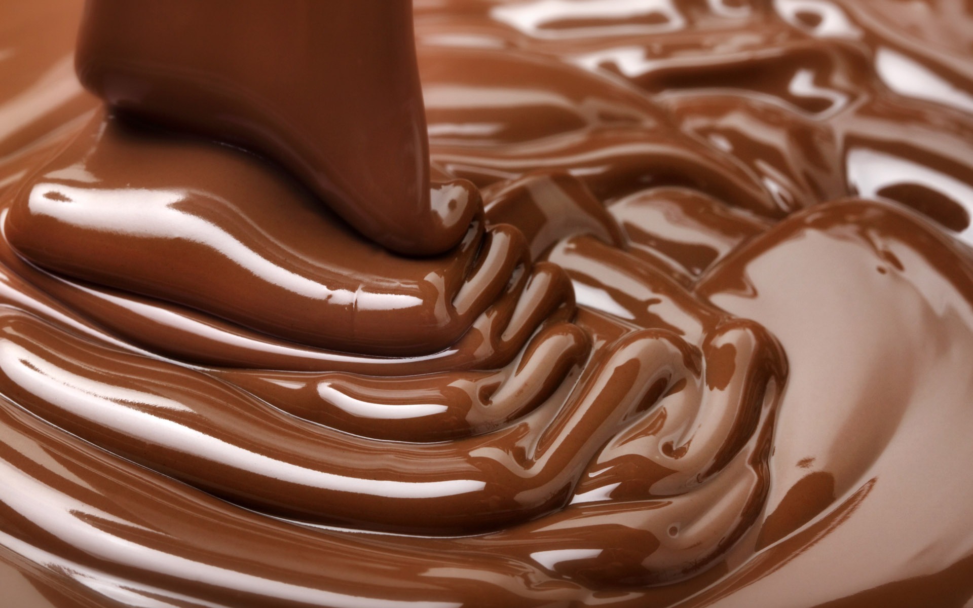 Melted chocolate drizzling over creamy dessert.