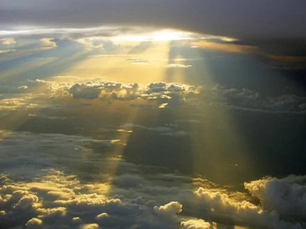 HD desktop wallpaper featuring a stunning nature scene with sunbeams breaking through clouds in the sky, illuminating the horizon. Tags include cloud, sunbeam, nature, sky.