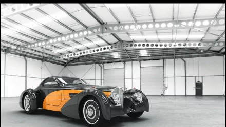 HD PC desktop wallpaper featuring a classic Delahaye vehicle with sleek black and orange design inside a spacious, well-lit industrial garage.