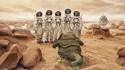A group of astronauts stands on a barren alien landscape, facing a strange, slimy creature. This HD desktop wallpaper captures a captivating sci-fi scene.