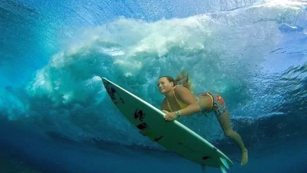 HD desktop wallpaper featuring a surfer underwater holding a surfboard, capturing the dynamic energy of surfing and ocean sports.