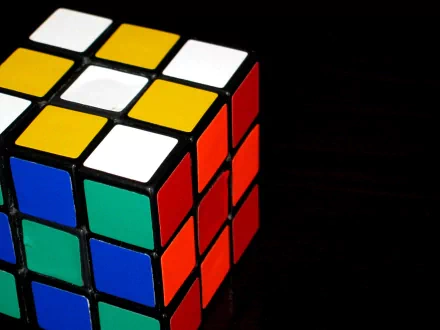 HD desktop wallpaper featuring a vibrant Rubik's Cube with colorful squares, set against a dark background.