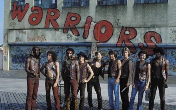 Image from the movie The Warriors, featuring a group of gang members in front of a graffiti-covered wall, showcasing iconic scenes from the film. HD PC desktop wallpaper and background.