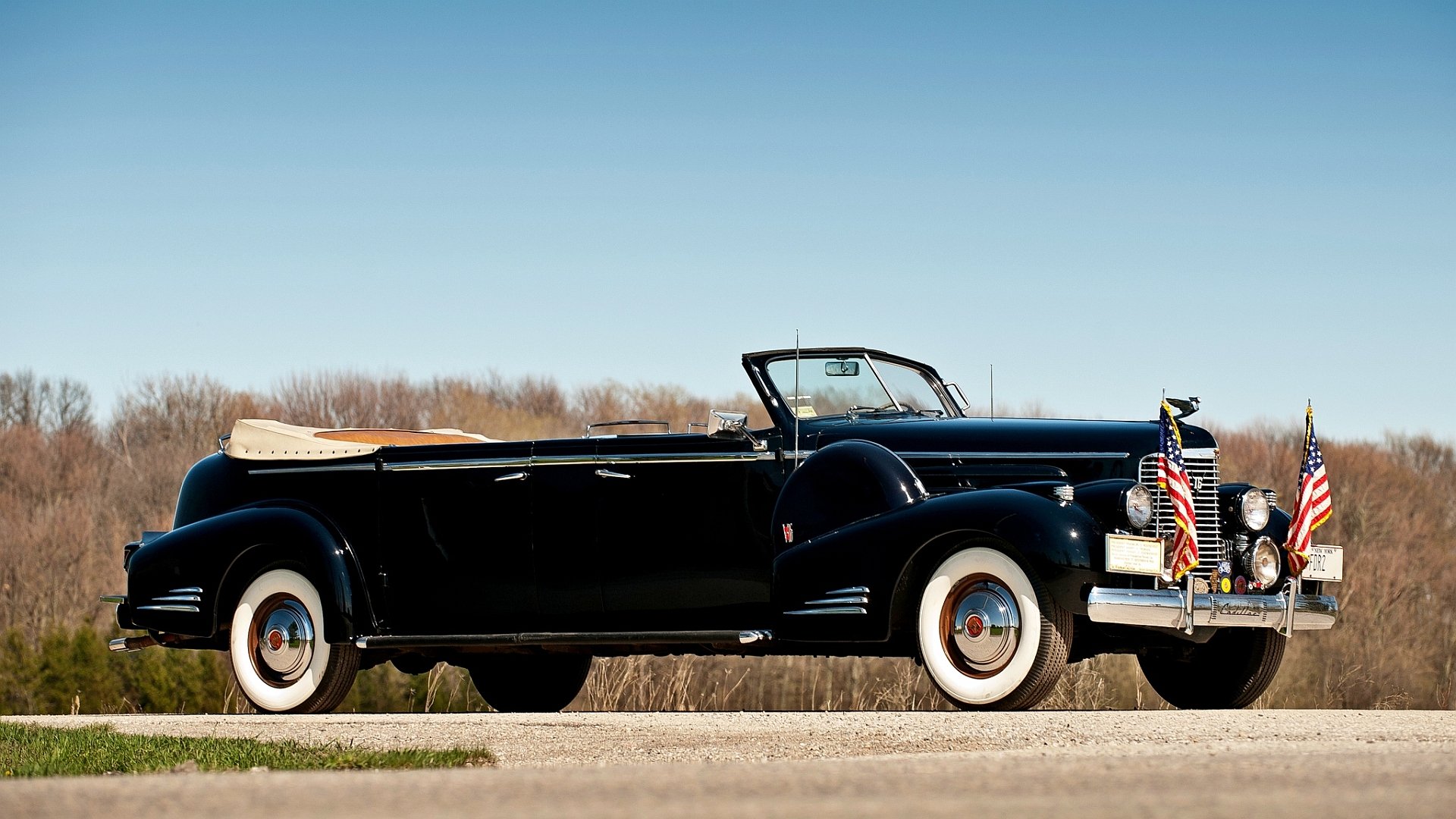 HD PC desktop wallpaper featuring a classic black Cadillac convertible parked outdoors under a clear blue sky.