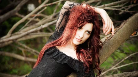HD desktop wallpaper featuring celebrity Susan Coffey with long red hair, posing gracefully against a natural backdrop of tree branches.