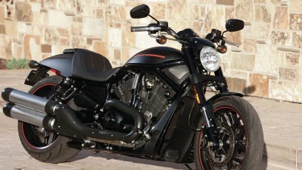 A sleek Harley-Davidson motorcycle parked against a stone wall, captured in an HD PC desktop wallpaper and background.