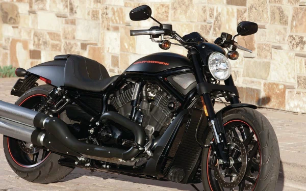 A sleek Harley-Davidson motorcycle parked against a stone wall, captured in an HD PC desktop wallpaper and background.