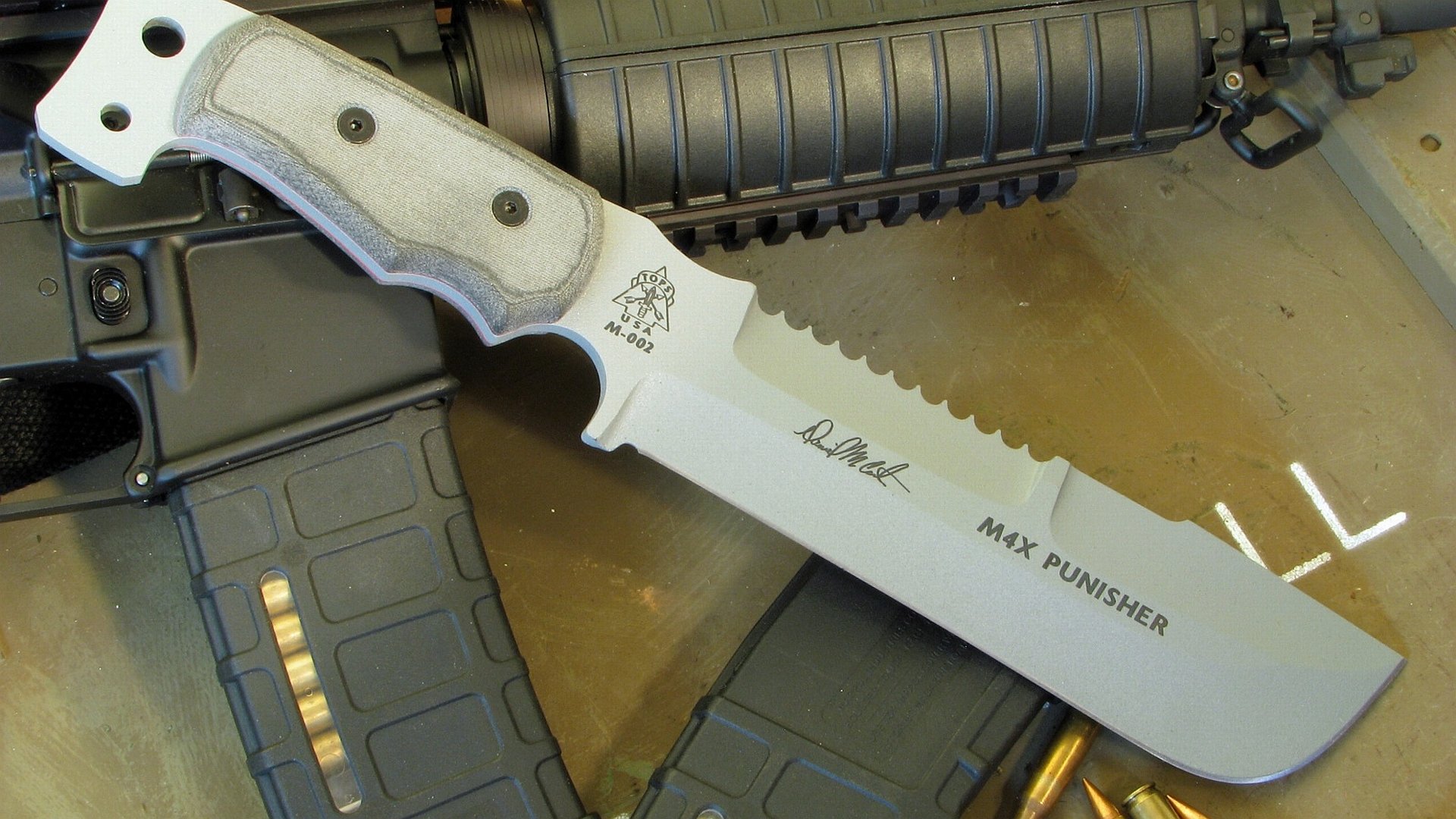 A close-up of a tactical knife with a sleek design, resting on a military-style background, showcasing its man-made craftsmanship as a striking HD desktop wallpaper.