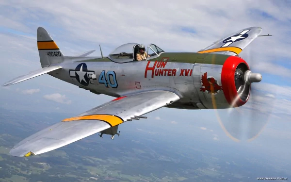 HD desktop wallpaper of a Republic P-47 Thunderbolt military aircraft flying above the landscape with clear skies, showcasing its distinctive markings and design.