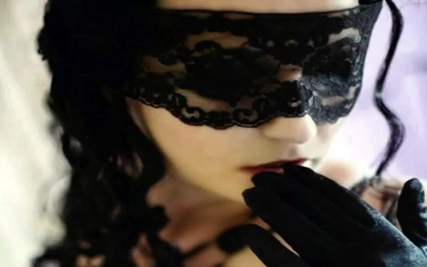 A dark, gothic image featuring a figure with a lace mask and black gloves, exuding an air of mystery. This HD wallpaper captures a striking blend of elegance and intrigue.