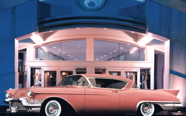 HD desktop wallpaper featuring a classic pink Cadillac parked in front of a modern building with large glass doors, showcasing vintage automotive elegance.