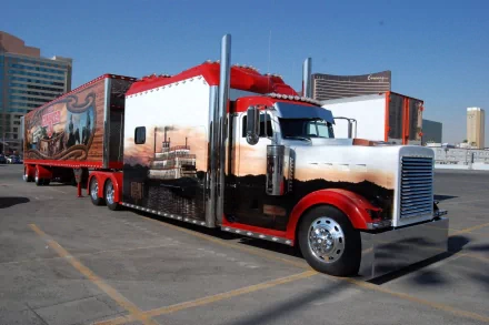 HD desktop wallpaper featuring a vibrant truck with custom reflective artwork, parked in an urban setting against a clear blue sky.
