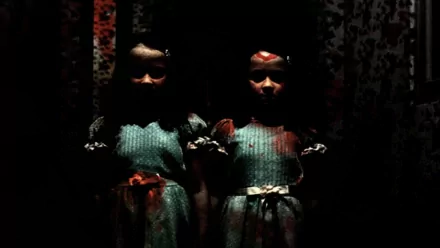 HD PC desktop wallpaper featuring the eerie, shadowed twin girls from the movie The Shining standing side by side in a dark, unsettling setting.