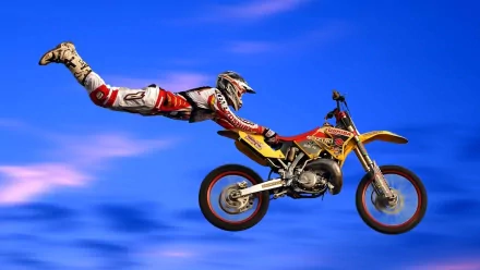 A motocross rider performing a mid-air stunt on a yellow motorcycle against a vivid blue sky, captured in HD for a dynamic sports desktop wallpaper and background.