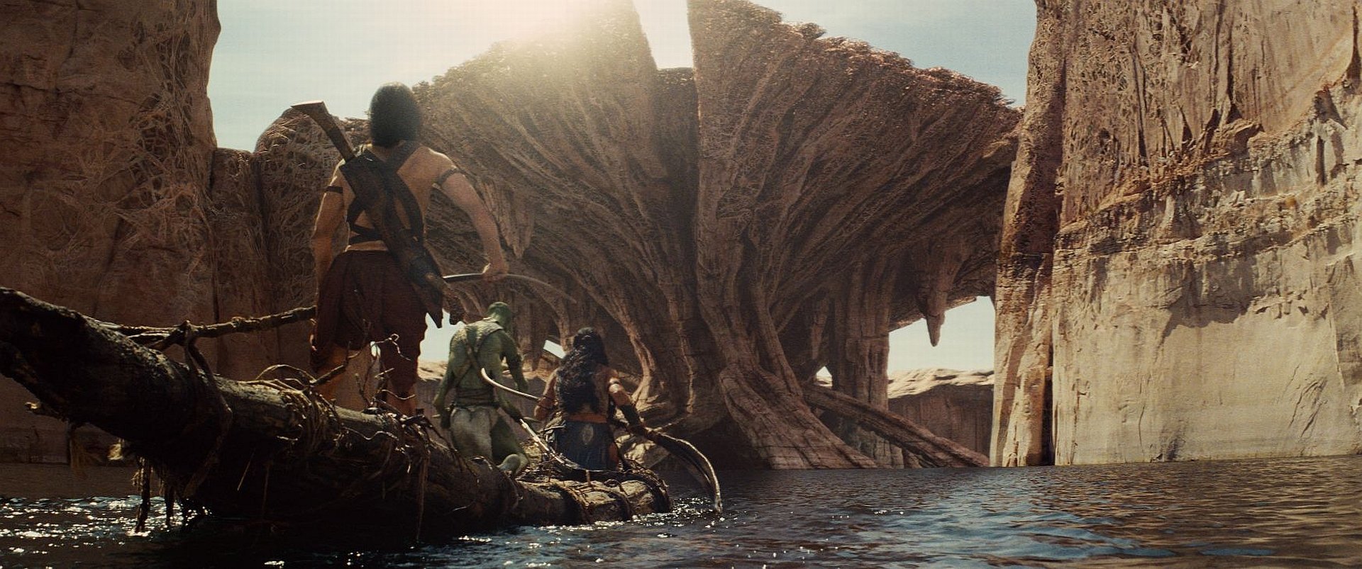 HD PC desktop wallpaper from the movie John Carter: silhouettes on a raft approach colossal alien, fan-like rock formations rising from the water beneath a pale sky.