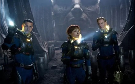 HD desktop wallpaper featuring Michael Fassbender and Noomi Rapace in their roles from the movie Prometheus, set in a dark, mysterious sci-fi environment.