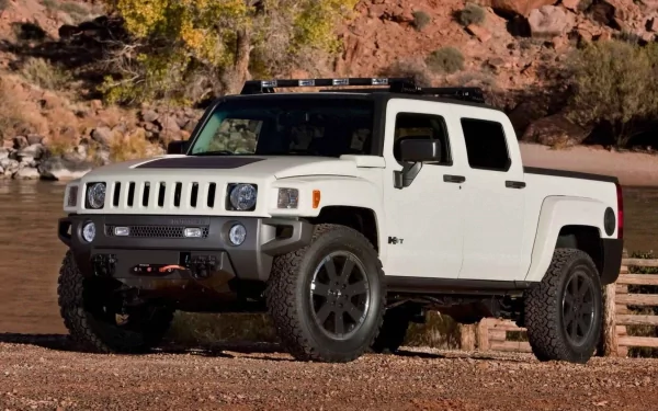 White Hummer pickup on a rocky riverbank in a desert canyon — HD PC desktop wallpaper background of an off-road vehicle.