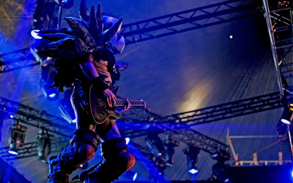 HD PC desktop wallpaper/background of Gwar onstage: a monstrous-costumed guitarist under dramatic blue concert lights, capturing raw heavy-metal performance energy.