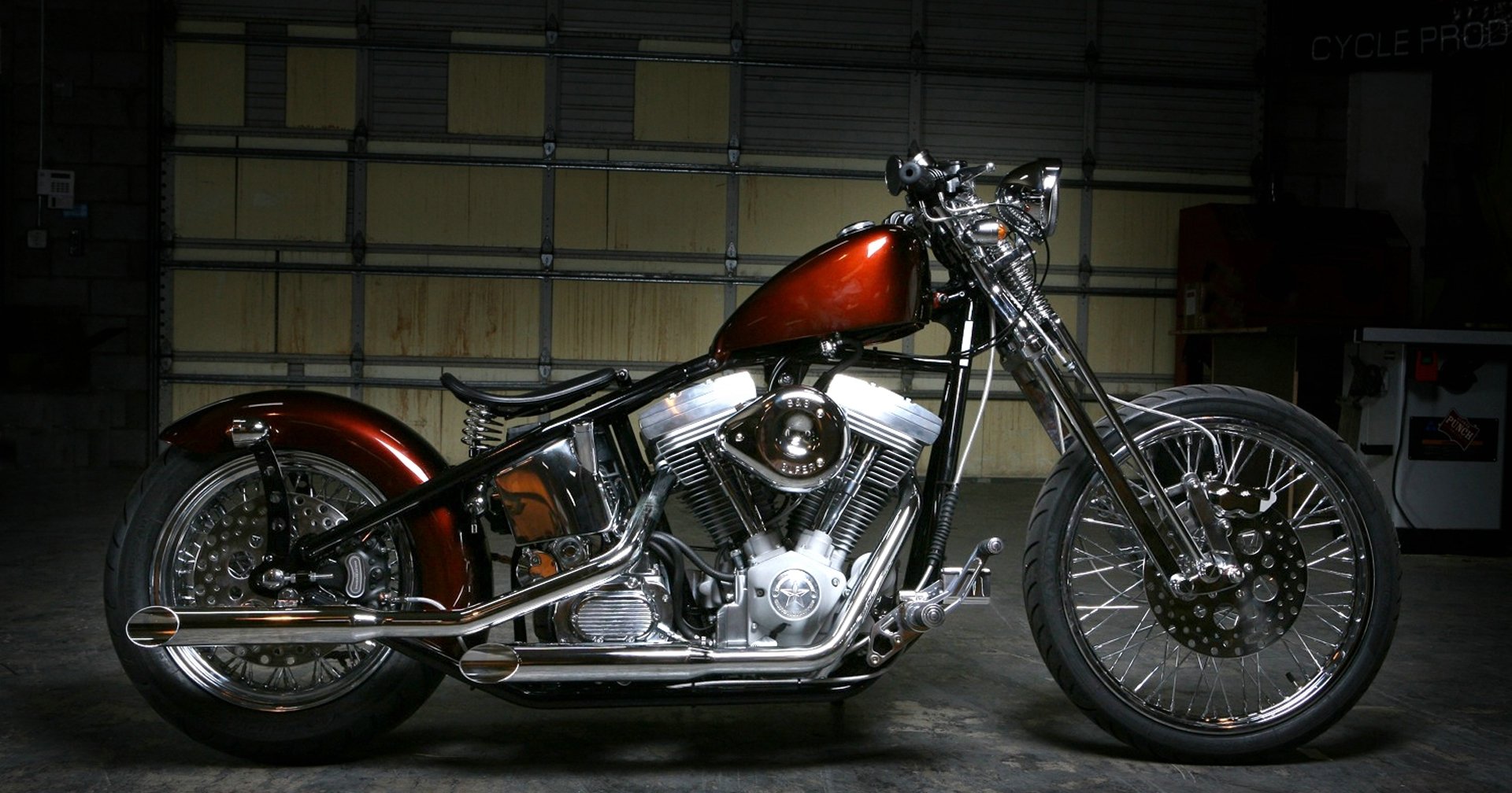 A polished Harley-Davidson motorcycle showcased in a dimly lit garage, featured as an HD PC desktop wallpaper and background.