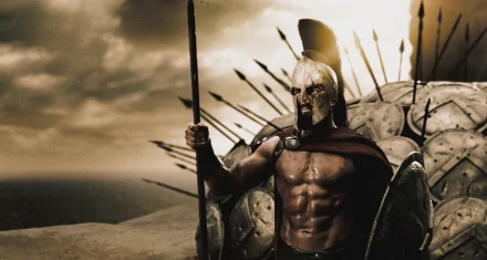 HD desktop wallpaper featuring Gerard Butler as King Leonidas, a Spartan warrior from the movie 300, equipped with a helmet, shield, and spear, standing resolute against a backdrop of shields and spears.