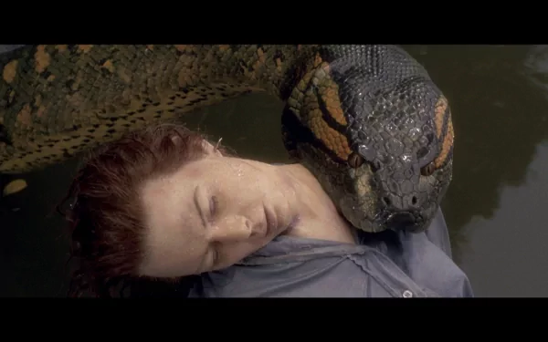 A dramatic scene from the movie Anaconda, featuring a woman submerged in water with a massive snake coiled around her, presented as a high-definition PC desktop wallpaper.