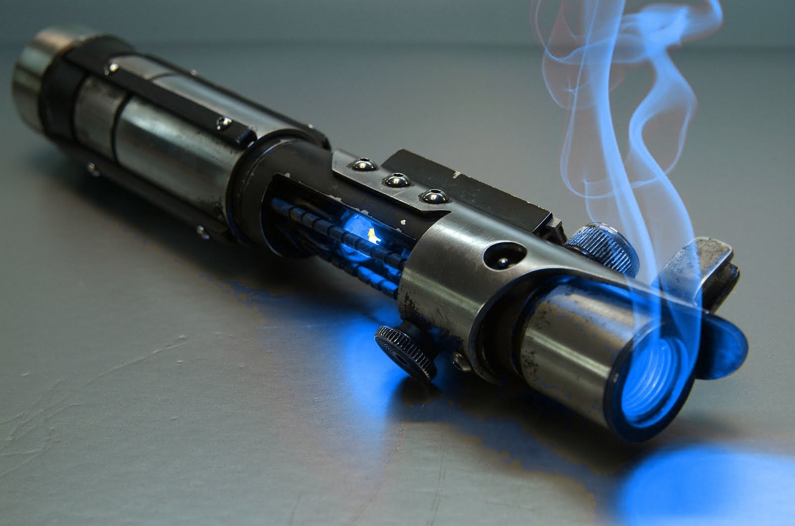 A detailed HD wallpaper featuring a glowing lightsaber with smoke, inspired by the Star Wars universe, evoking a sense of adventure and sci-fi fantasy.