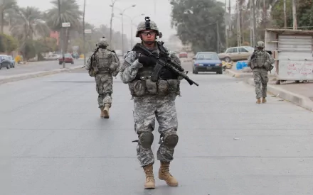U.S. Army Infantry soldiers armed and patrolling a street in a war zone, captured in high definition for a military-themed desktop wallpaper.