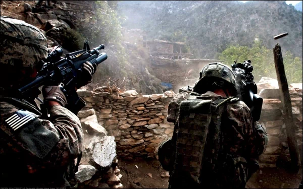 HD desktop wallpaper showing two U.S. Army Infantry soldiers armed with guns in a rocky war zone, engaged in a tactical military operation.